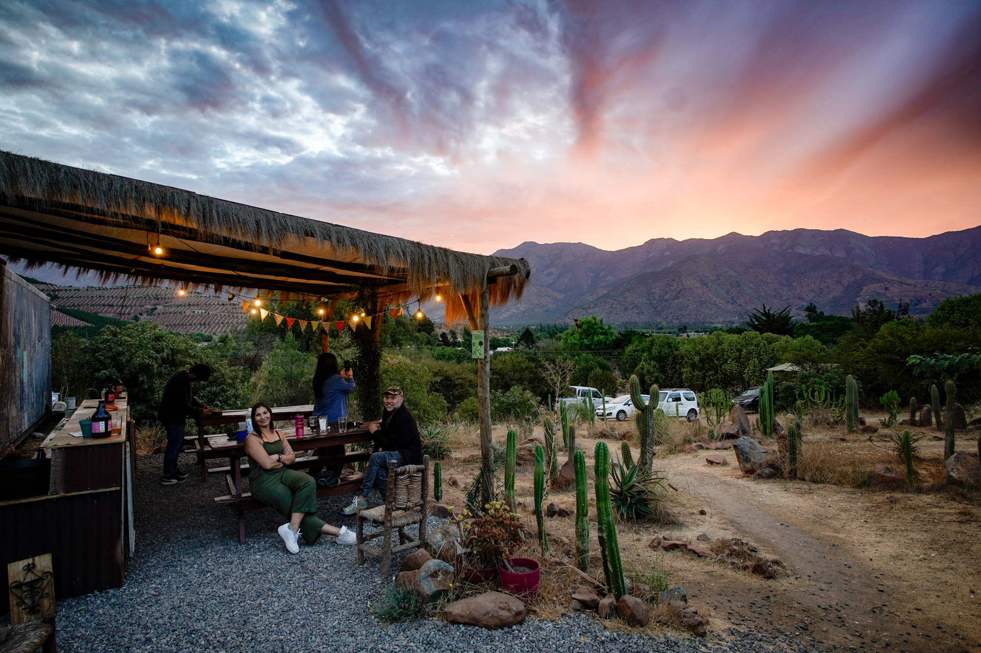 Visitantes disfrutando cervezas Preece al atardecer en la terraza con vista a las montañas